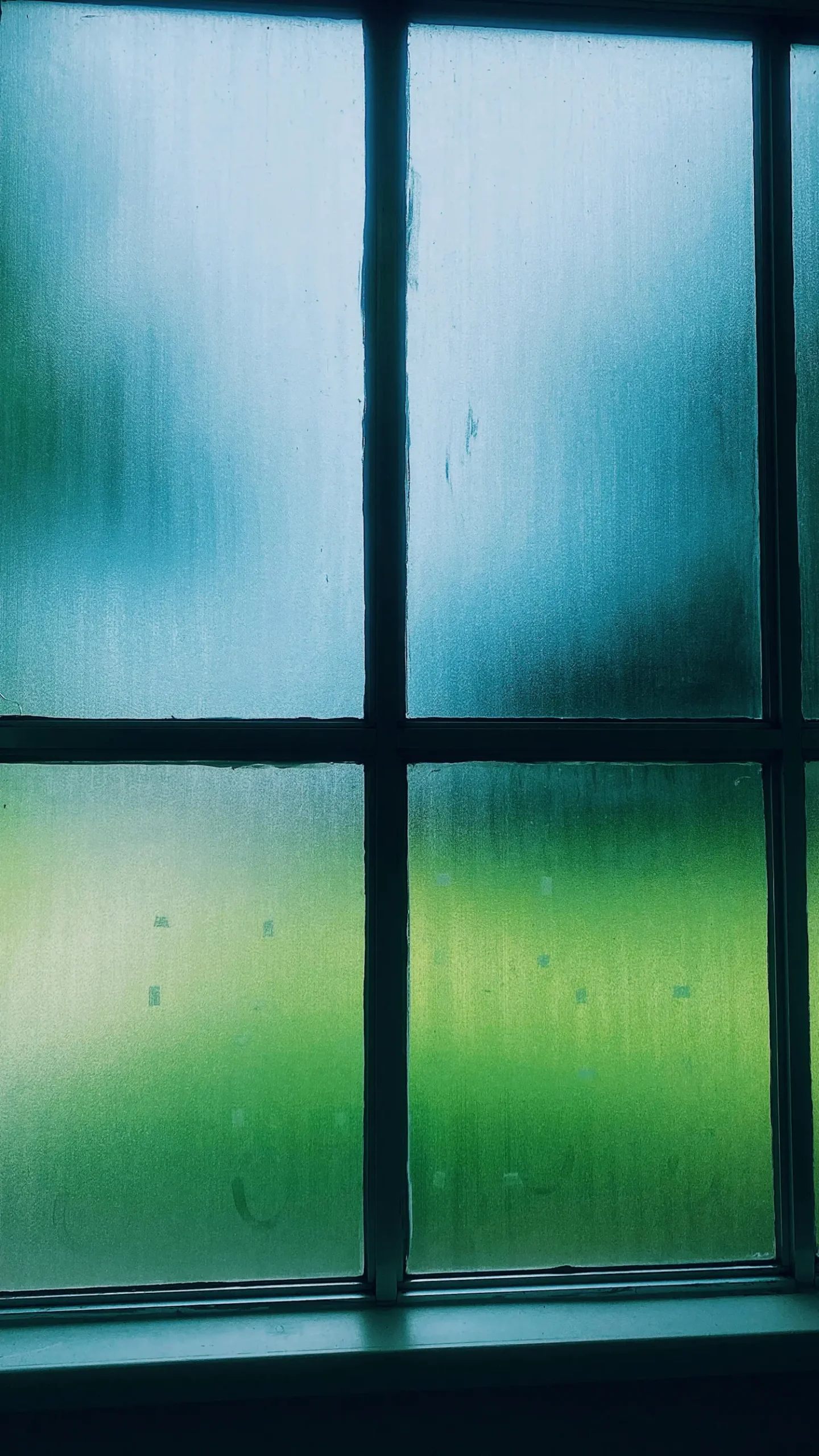 Nahaufnahme von Kondenswasser an einer Fensterscheibe im Winter.