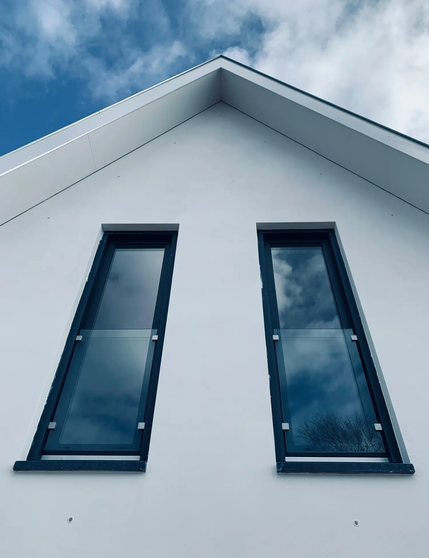 Nahaufnahme eines modernen Passivhaus-Fensters mit Dreifachverglasung in einer Holzfassade.